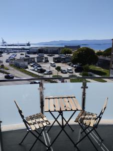 two chairs sitting on a balcony with a parking lot at Apartamentos Mar de la Concha in Vilagarcia de Arousa
