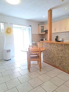 a kitchen with a wooden table and a wooden chair at Studio proche de Perpignan in Peyrestortes