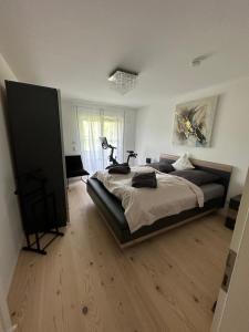 a bedroom with a large bed and a wooden floor at Chiemgau Ferienhaus Premium by BellaVita in Bad Endorf