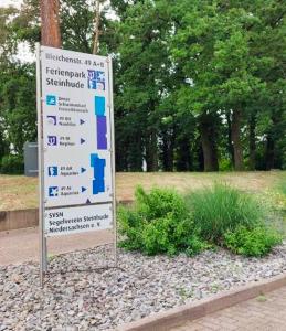 ein Schild in einem Park neben einigen Büschen in der Unterkunft Ankerplatz-Steinhude in Wunstorf