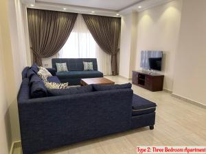 a living room with a blue couch and a tv at Luxury Apartments Beside Mall of Arabia and Dar Al-Fouad hospital - Families only- No Alcoholic Beverages in 6th Of October