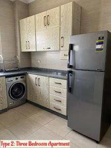 a kitchen with a refrigerator and a washing machine at Luxury Apartments Beside Mall of Arabia and Dar Al-Fouad hospital - Families only- No Alcoholic Beverages in 6th Of October