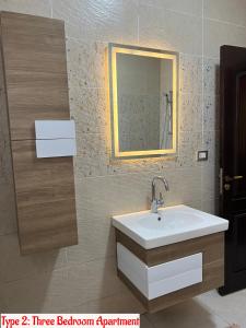 uma casa de banho com um lavatório e um espelho em Luxury Apartments Beside Mall of Arabia and Dar Al-Fouad hospital - Families only- No Alcoholic Beverages em Cidade 6 de Outubro