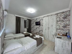 a hotel room with two beds and a television at Opera Avenue Hotel in Yerevan