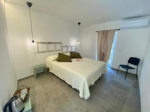 a bedroom with a white bed and a chair at Relais PINF in Malcesine