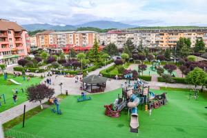 a park with a playground and slides and buildings at Acasă la Maria in Petrila