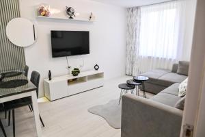a living room with a couch and a tv at Acasă la Maria in Petrila