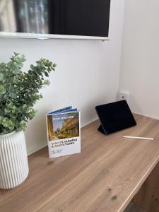 a book sitting on top of a wooden table with a plant at Chambre climatisée lit double dans villa - Proche Centre Tramway in Montpellier