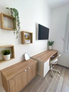 an office with a desk and a tv on a wall at Chambre climatisée lit double dans villa - Proche Centre Tramway in Montpellier