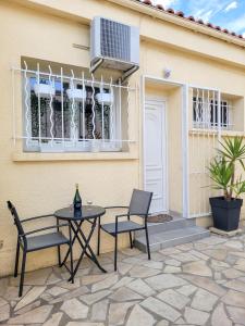 un patio con 2 sillas y una mesa frente a una casa en Chambre climatisée lit double dans villa - Proche Centre Tramway, en Montpellier