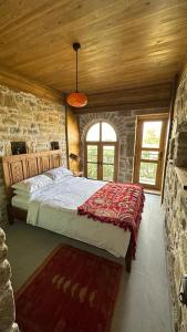 um quarto com uma cama grande num edifício de pedra em KİNZİ İMROZ em Gokceada Town