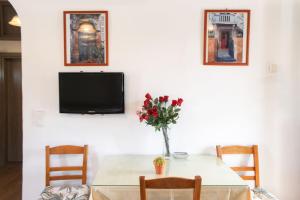 a dining room with a table with a vase of flowers at Stone house with Amazing View in Kótronas