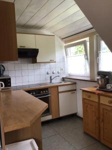een keuken met een wastafel en een fornuis top oven bij connysferienwohnung in Bad Laasphe