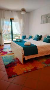 a bedroom with a large bed and a rug at Cantinho do Sol - Sea view, Quiet, Cozy and Relaxing Flat in Armação de Pêra +58 photos