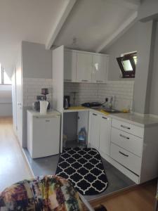 una cocina con armarios blancos y una alfombra en el suelo en Özel Villa, en Sarıyer