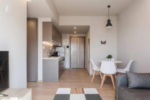 Apartment in Keramikos, Athens في أثينا: غرفة معيشة مع أريكة وطاولة ومطبخ