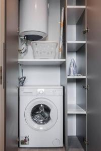 lavadora y secadora en una habitación con estanterías en Apartment in Keramikos, Athens, en Atenas