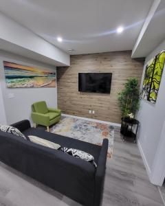 Luxury suite in Calgary NW في كالغاري: غرفة معيشة مع أريكة وتلفزيون بشاشة مسطحة