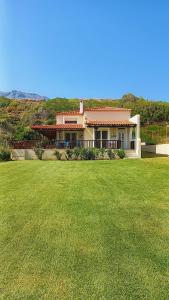 a house with a large lawn in front of it at Villa Dimitra in Mourteri