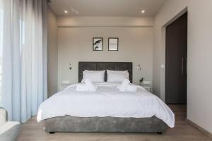 Un dormitorio con una cama grande con sábanas y almohadas blancas. en Apartment in Keramikos, Athens, en Atenas