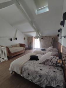 1 dormitorio grande con 2 camas y sofá en Gîte Le Lau-Kal, en Septfonds