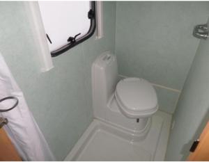 a small bathroom with a toilet and a window at Olga caravane in Aywaille