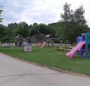 un parco con parco giochi con scivolo e giochi di Olga caravane ad Aywaille