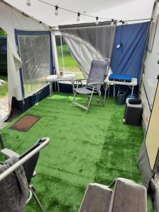 ein Zelt mit Stühlen und Tischen in der Unterkunft Olga caravane in Aywaille