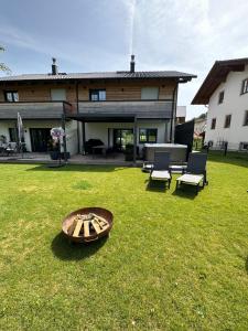 a house with a wooden boat on the lawn at Chiemgau Ferienhaus Premium by BellaVita in Bad Endorf