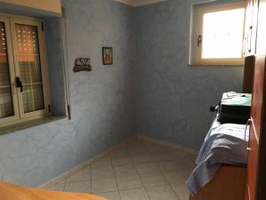 um pequeno quarto com paredes azuis e uma janela em La Piccola Valle em Vallefiorita