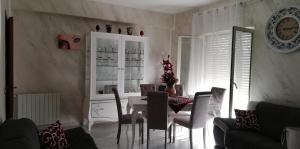 uma sala de estar com mesa e cadeiras e um relógio em La casa di Anna em Villabate