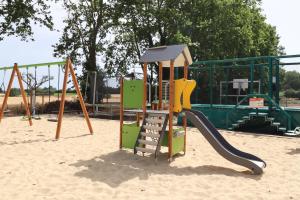 een speeltuin met een glijbaan in het zand bij Chambres d'hôtes avec Jacuzzi et Piscine au Mas de Cadoule in Saint-Just