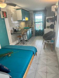 Zimmer mit einem blauen Bett und einer Küche in der Unterkunft Studio Ti’ Colibri in Sainte-Marie