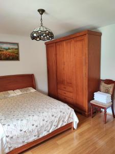 ein Schlafzimmer mit einem Bett, einem Schrank und einem Stuhl in der Unterkunft Уютные апартаменты - 400 метров от пляжа in Sutomore