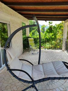 einen Stuhl auf einer Veranda mit einer Terrasse in der Unterkunft Уютные апартаменты - 400 метров от пляжа in Sutomore