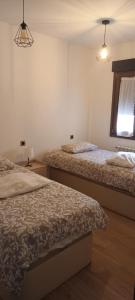 a bedroom with two beds and a window at Apartamentos Casa de los ramos 2 in Vinuesa