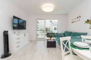Apartamenty Mierzeja NCNK Baltic Twins Sztutowo في شتوتوفو: غرفة معيشة مع أريكة وطاولة