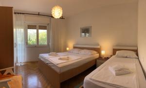 a bedroom with two beds and a window at Apartment Sersic in Baška