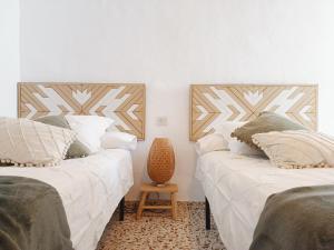 twee bedden naast elkaar in een kamer bij Las Pizarrillas: tu hogar en este blanco pueblo in Frigiliana