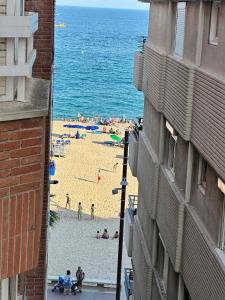 un grupo de personas en una playa cerca del océano en Sunnyside Lloret, en Lloret de Mar