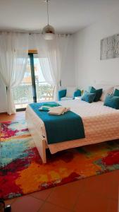 a bedroom with a large bed with a colorful rug at Cantinho do Sol - Sea view, Quiet, Cozy and Relaxing Flat in Armação de Pêra