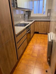 cocina con armarios de madera, fregadero y suelo de baldosa en Sunnyside Lloret, en Lloret de Mar