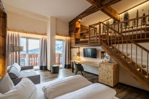 a living room with a staircase and a couch at Heidi-Hotel Falkertsee - Kinderhotel in Patergassen