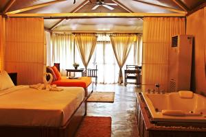 1 dormitorio con 2 camas y bañera en Pai Vimaan Resort, en Pai