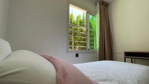 - une chambre avec un lit blanc et une fenêtre dans l'établissement 100% women suite (Rooms with private bathrooms), à Rabat