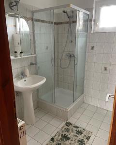 y baño con ducha y lavamanos. en Erdőgyöngye Vendégház CSÖDE, en Csöde