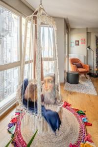 Ein Mann, der in einer Schaukel im Wohnzimmer sitzt in der Unterkunft Modern Stylish Flat in The Center of The City in Istanbul