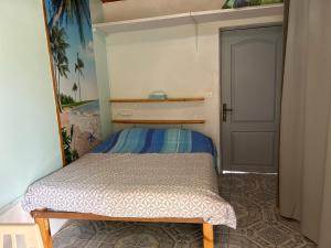 a small bed in a small room with a door at 2 à 4 pers appartement dans Maisonnette piscine chambre double salle de bain privatif in Saint-Amarin