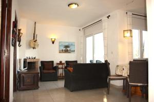 - un salon avec un canapé, des chaises et une télévision dans l'établissement Mas Mundo - 4 Ferienhäuser in Calonge / Girona, à Gérone