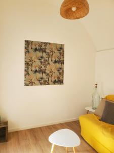 una sala de estar con un sofá amarillo y una pintura en la pared en Corbara ,Pietralta, en Corbara